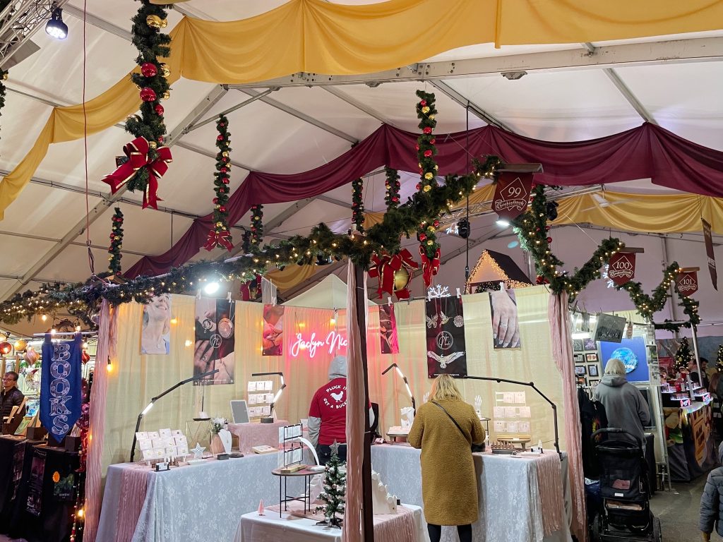 a woman shopping in front of a festively decorated shopping booth