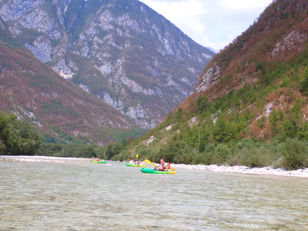 group of kayakers paddling down the river in the soca valley