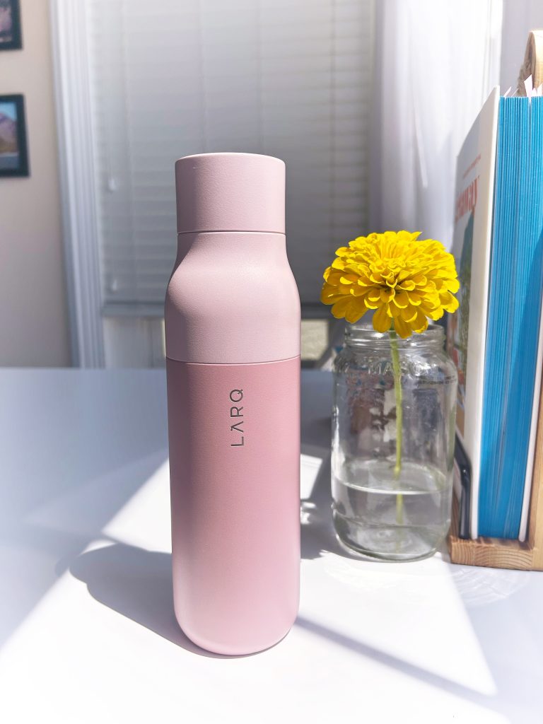 pink larq water bottle next to a yellow flower