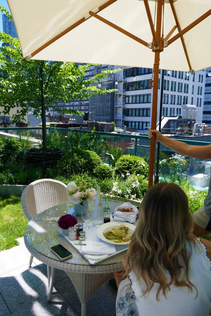 a girl sitting down eating lunch on a terrace