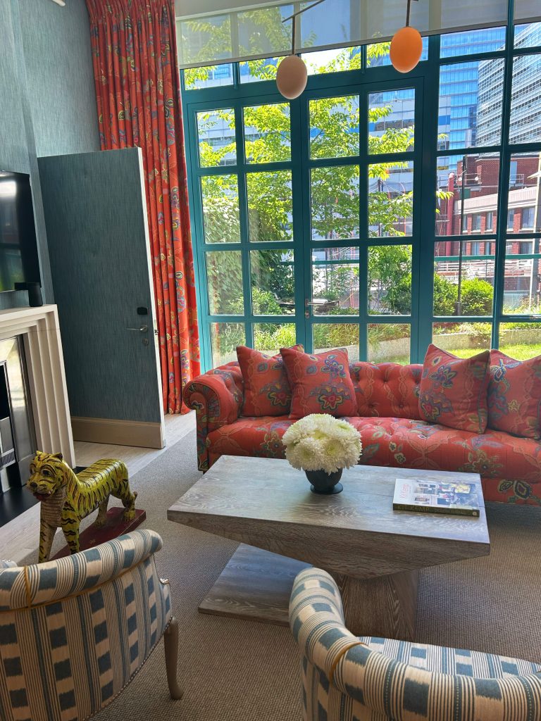 orange couch with flowers and patterned chairs
