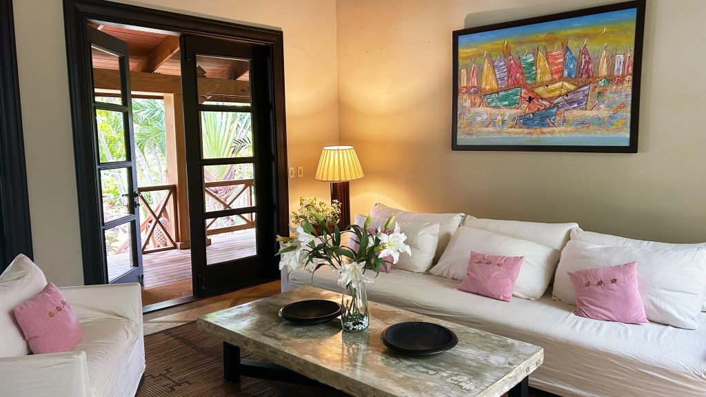white couch with pink pillows and flowers on coffee table
