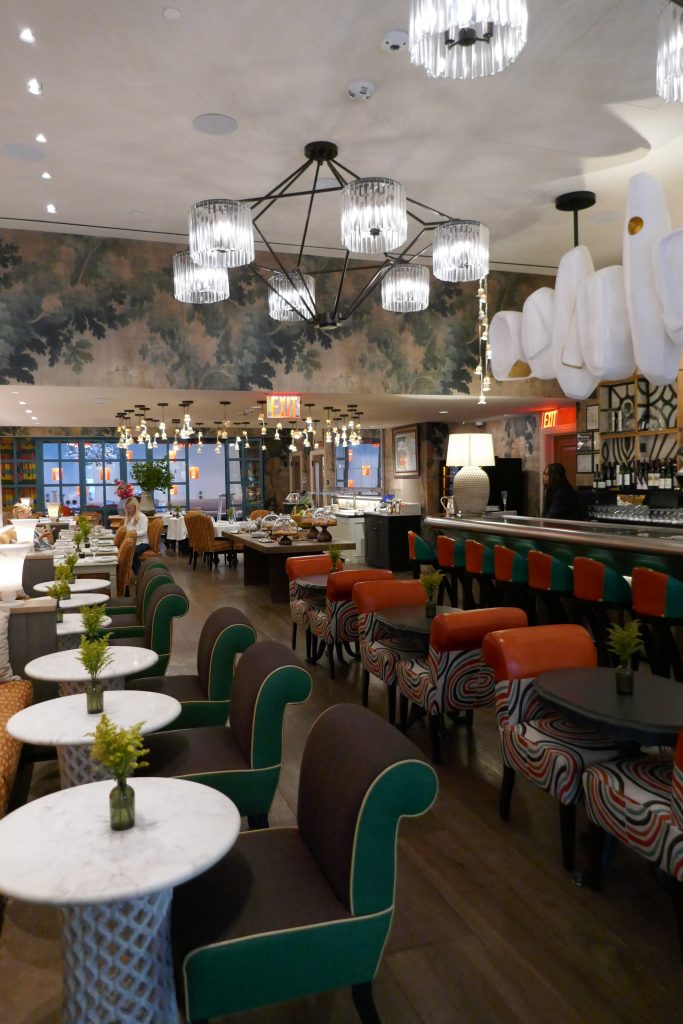 row of small dining tables and a bar with a lamp