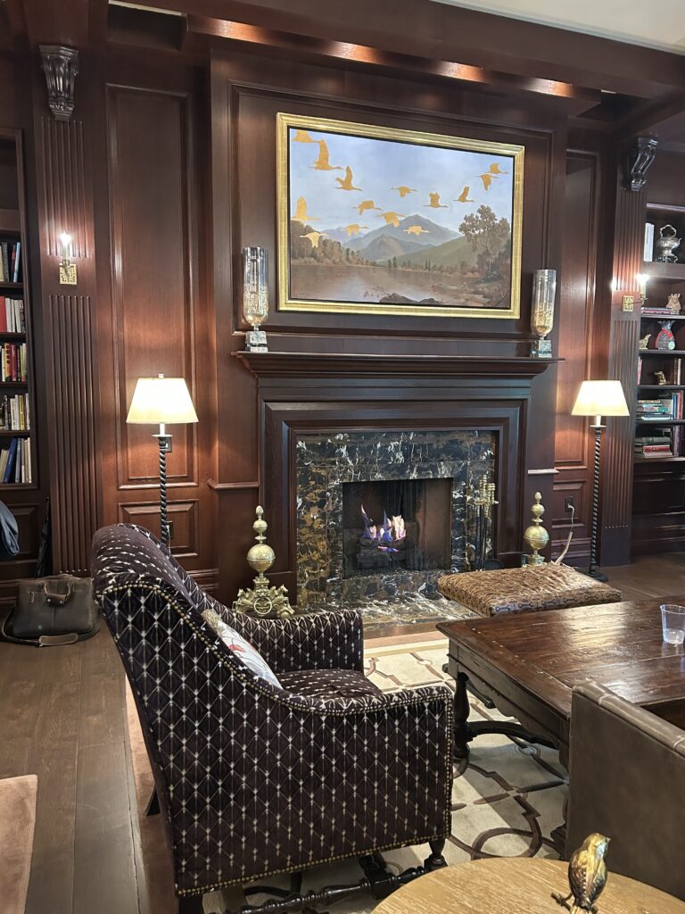 darkly colored sitting room by a fireplace