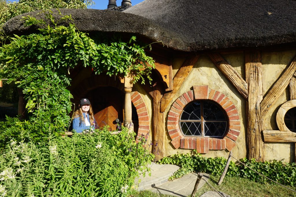 girl sitting on porch of a hobbit home